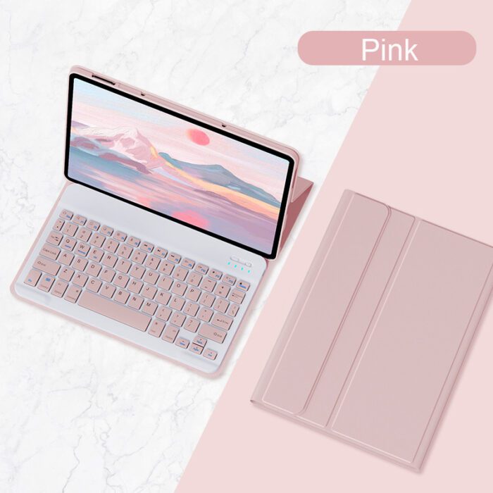 A pink laptop and keyboard on the table.