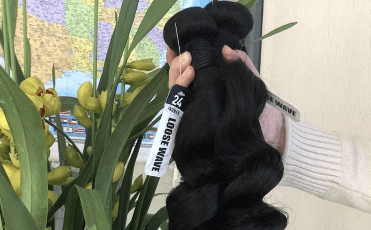 A person holding some black hair in their hand