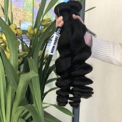 A person holding some hair extensions in their hand.